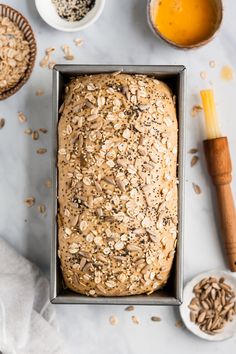 a loaf of oatmeal bread sitting in a pan next to other ingredients