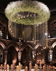 a large chandelier with candles hanging from it's ceiling in a building