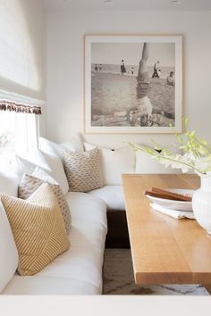 a living room filled with furniture and a large painting on the wall above the couch