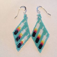 a pair of beaded earrings with colorful parrots on the front and back side