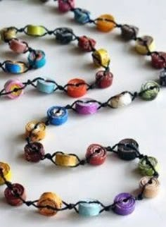 a multicolored beaded necklace on a white surface