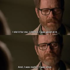 a man with glasses and a beard stares at another man's reflection in the mirror