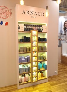 a woman standing in front of a store display with products on it's shelves