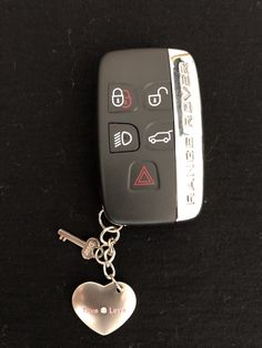 a car keychain with a heart shaped charm attached to it's side