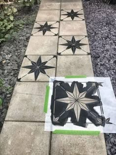 some black and white tiles on the ground with green trimmings in front of them