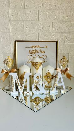 the word love spelled out with candles in front of a white background and gold accents