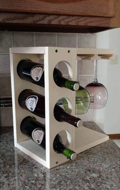 a wooden wine rack with six bottles in it