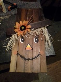 a scarecrow made out of wood with sunflowers on it