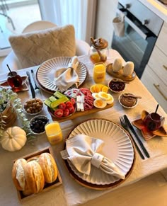 the table is set with plates, silverware and other items for an elegant breakfast