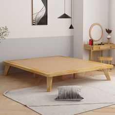 a wooden bed frame sitting on top of a white rug next to a table and chair