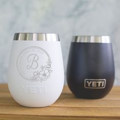 two yeti cups sitting on top of a wooden table next to eachother