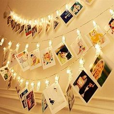 a bunch of pictures hanging from a string with lights on it and some photos attached to the strings