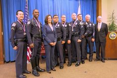 a group of police officers standing next to each other in front of a blue curtain