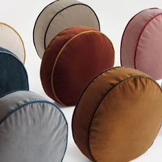 several different colored round pillows sitting next to each other