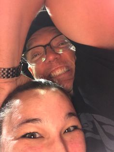 two people posing for the camera with their arms around each other and one person wearing glasses