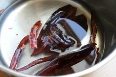 some red peppers are in a silver bowl