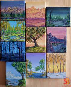 nine paintings of trees and mountains are arranged on a wooden surface, each painted in different colors