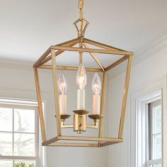 a chandelier hanging from the ceiling in a room with white walls and windows