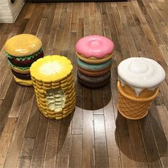 three ice cream cones, two donuts and one hamburger are on the floor