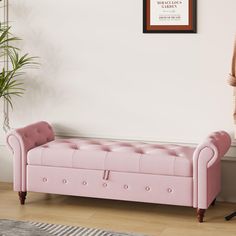 a pink bench sitting in front of a white wall