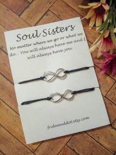 two bracelets sitting on top of a wooden floor next to a card that says soul sisters