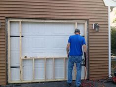 a man in blue shirt and jeans standing next to a garage door