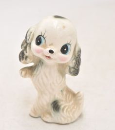 a small white dog figurine with blue eyes