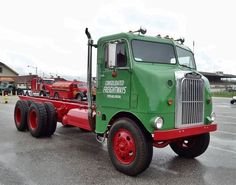 a green semi truck parked in a parking lot