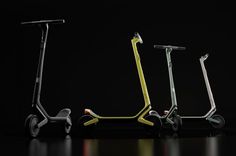 three scooters are lined up against a black background, one is yellow and the other is green