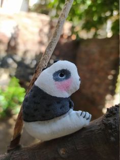 a small stuffed animal sitting on top of a tree branch