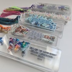 four different colored beads in plastic cases on a white surface with text below them that reads, break the good news special convention