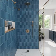 a blue tiled bathroom with gold fixtures and marble counter tops, along with an open shower