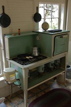 an old fashioned stove with pots and pans on the top shelf in a kitchen