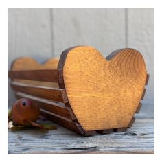 a wooden heart shaped box sitting on top of a table