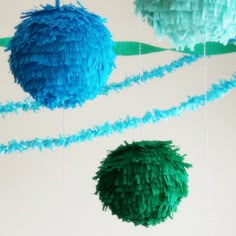 three blue and green paper balls hanging from strings