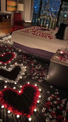 a bedroom decorated for valentine's day with candles in the shape of a heart