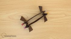 two small propeller shaped objects sitting on top of a wooden table