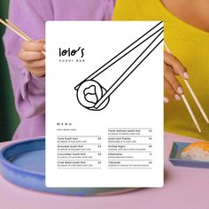 a person holding chopsticks in front of a menu