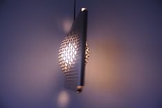 a light hanging from the side of a wall next to a blue wall with lights on it