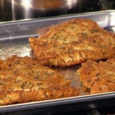 four crab cakes sitting on top of a metal pan