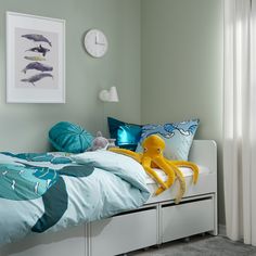 a bed room with a neatly made bed and an octopus stuffed animal