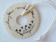 a white ornament with writing on it and a string attached to the tag