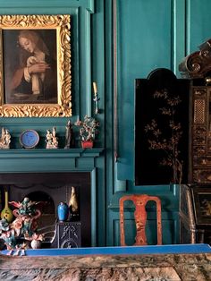 a living room filled with furniture and a painting on the wall above a fire place