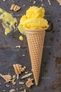 an ice cream cone with chunks of wood shaving on the ground next to it