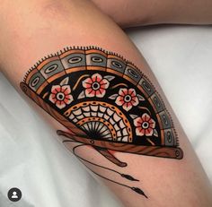 a woman's leg with an artistic tattoo design on the side of her thigh