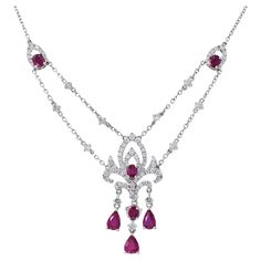 Presenting our stunning 18KT White Gold Genuine Ruby and Diamond Drop Necklace, a masterpiece of elegance and sophistication. This exquisite necklace showcases the beauty of genuine Burmese rubies, featuring a total of 2.25 carats of pear and oval-cut rubies. These radiant gemstones are beautifully complemented by 1.26 carats of round-cut diamonds, which boast G color and VS1-VS2 clarity. The result is a truly captivating piece of jewelry that exudes luxury and grace. Length 17 inches. Weight 9. Ruby And Diamond Necklace, Diamond Drop Necklace, Cluster Necklace, White Gold Necklaces, Modern Necklaces, Diamond Drops, Ruby Diamond, Girly Jewelry, Drop Necklace