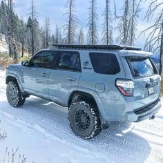 a silver four - doored vehicle is parked in the snow