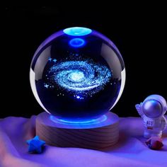 an image of a glass ball with stars in it and a small spaceman next to it