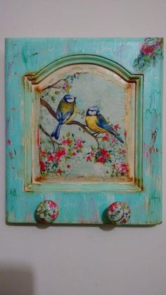 two birds are sitting on a branch with flowers painted on it's wall frame