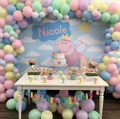 a table with balloons, cake and decorations for a peppa pig themed birthday party